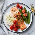 Grilled salmon with cherry tomato bruschetta, served with green beans and rice.