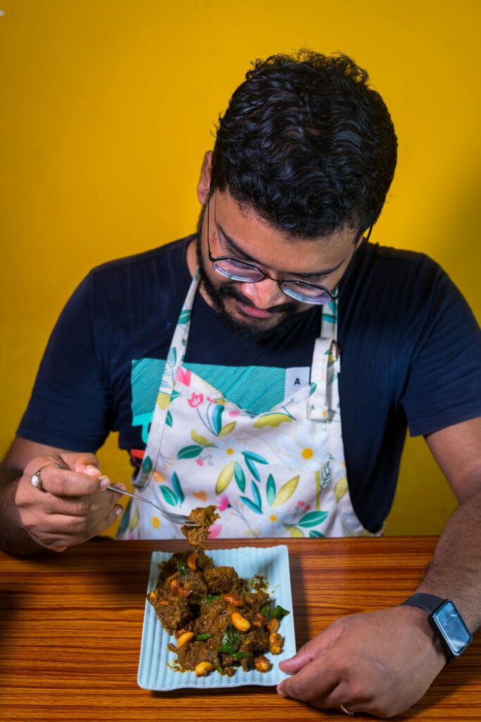 Man eating a flavorful dish in a colorful setting, capturing culinary delight.